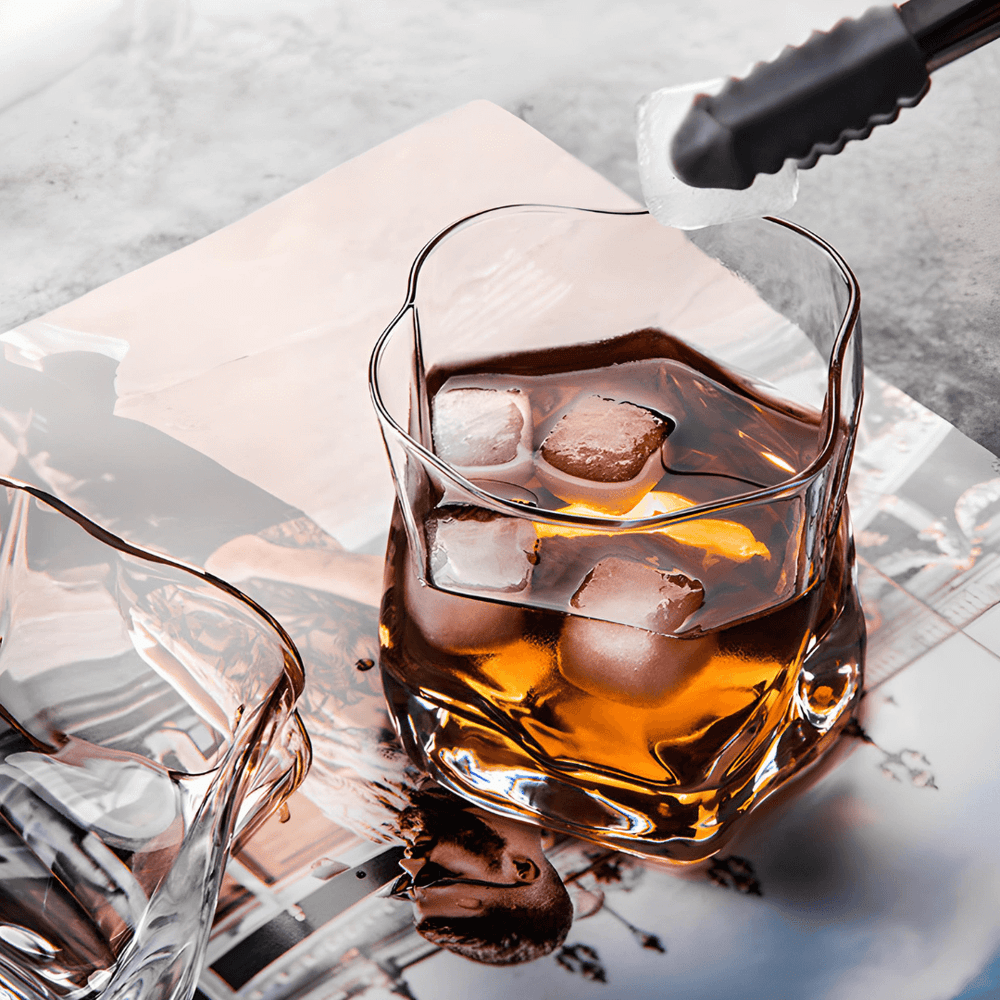 a glass of whiskey with ice cubes
