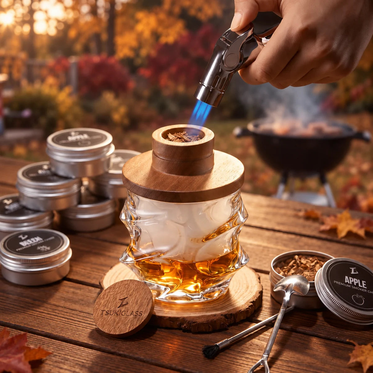 A whisky smoker and crystal glass with wood chips on an autumn table