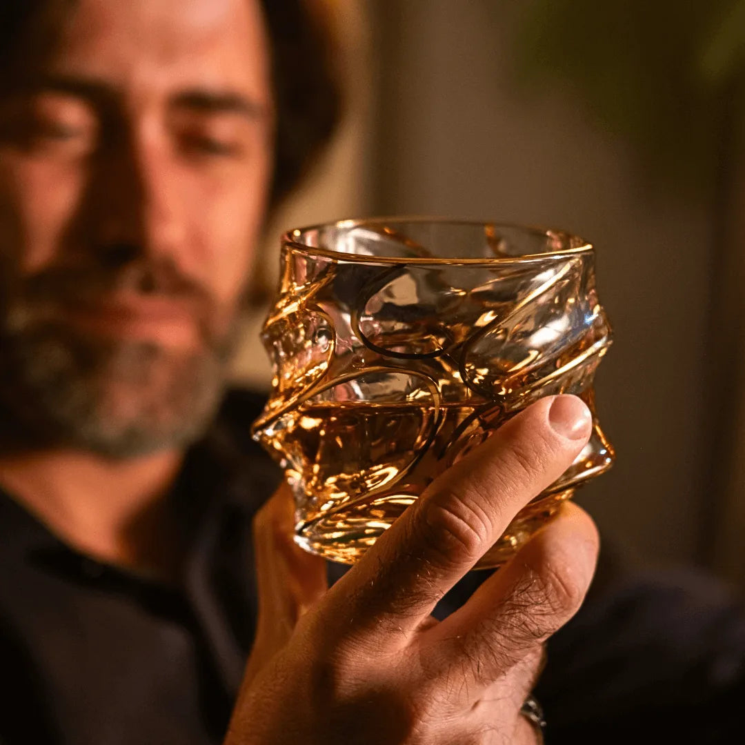 A person holding a sculptural Japanese whisky glass