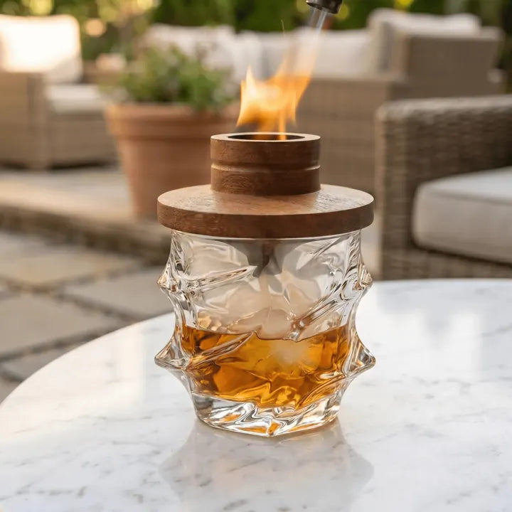 Smoker lid with flame on a Storm glass on a patio table